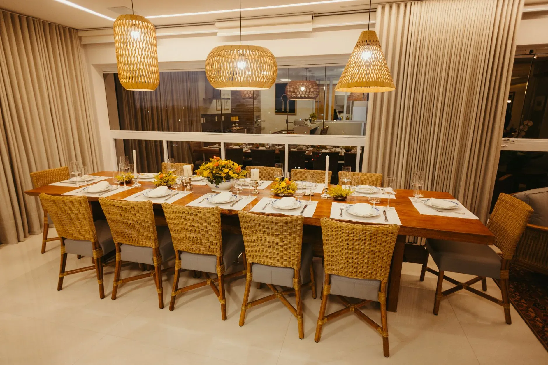 A beautifully arranged dining table with rattan chairs and floral centerpiece in a modern setting.