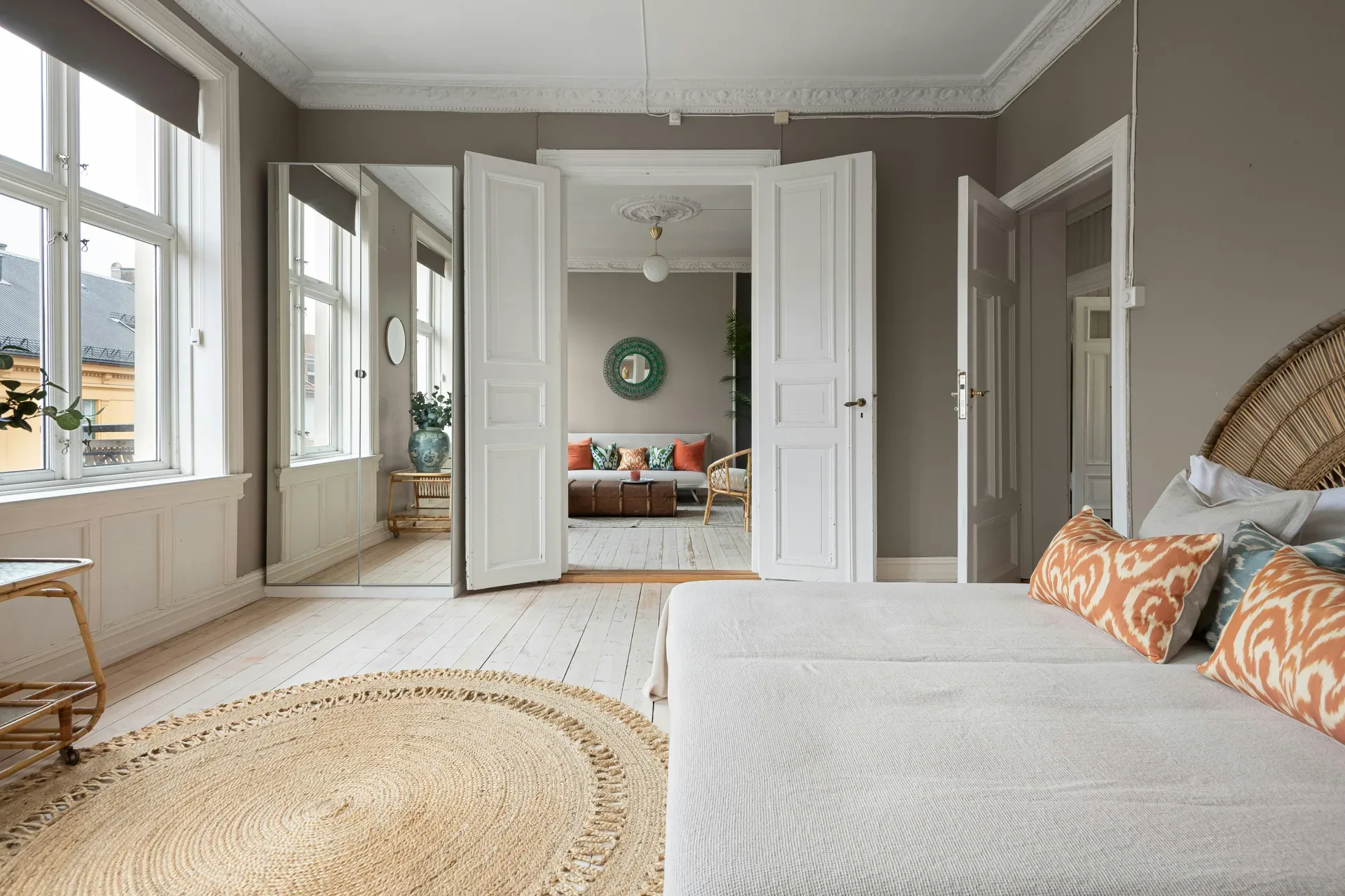 A bedroom with a large bed and large windows