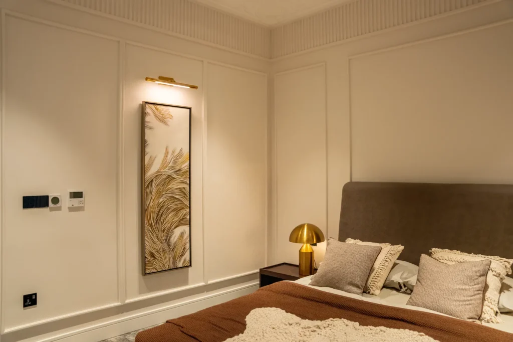 A cozy modern bedroom featuring minimalist decor with neutral tones and stylish lighting.