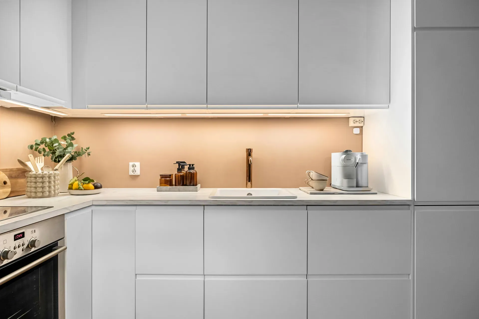 A kitchen with a stove, sink, and oven
