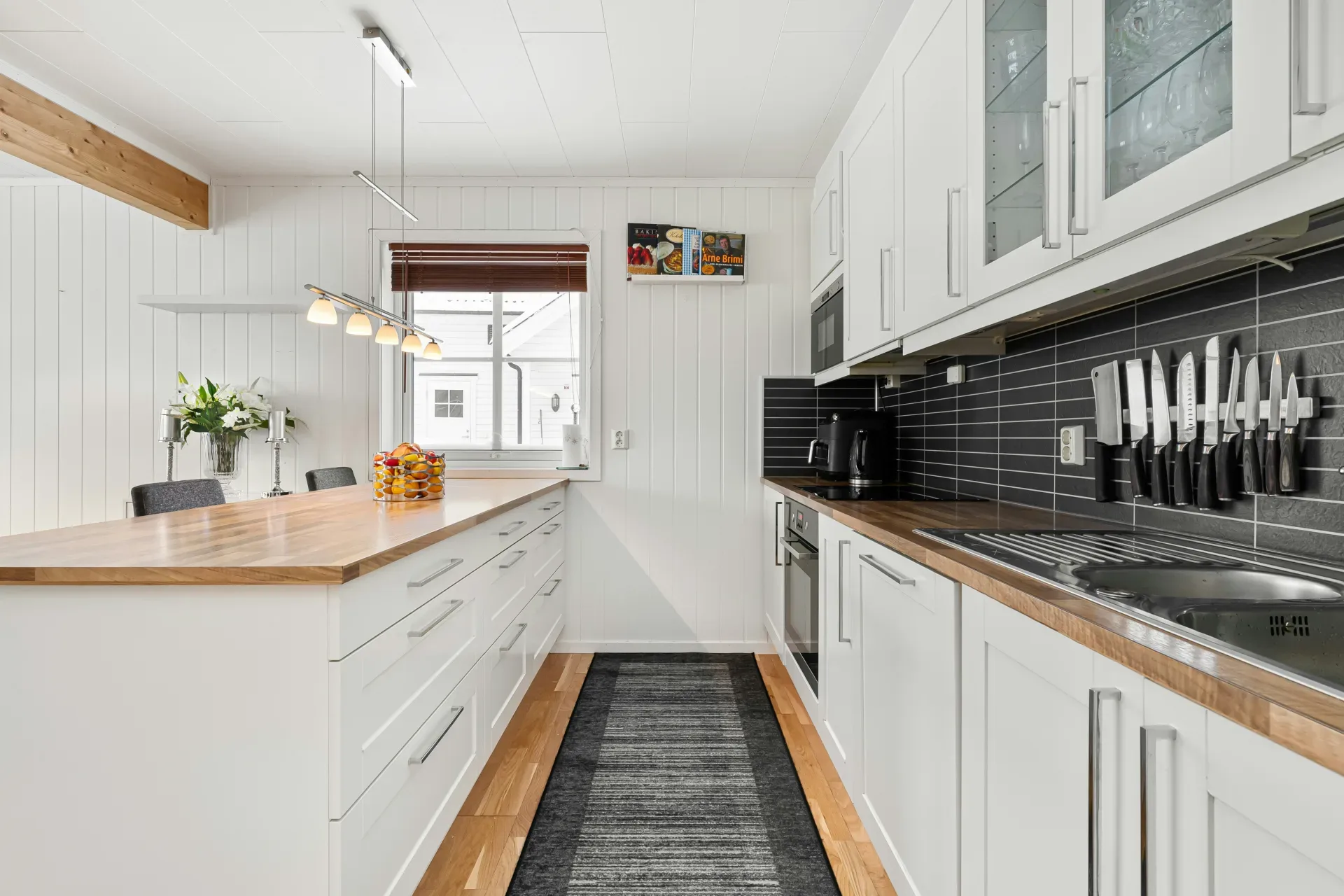 A kitchen with white cabinets and a black floor
