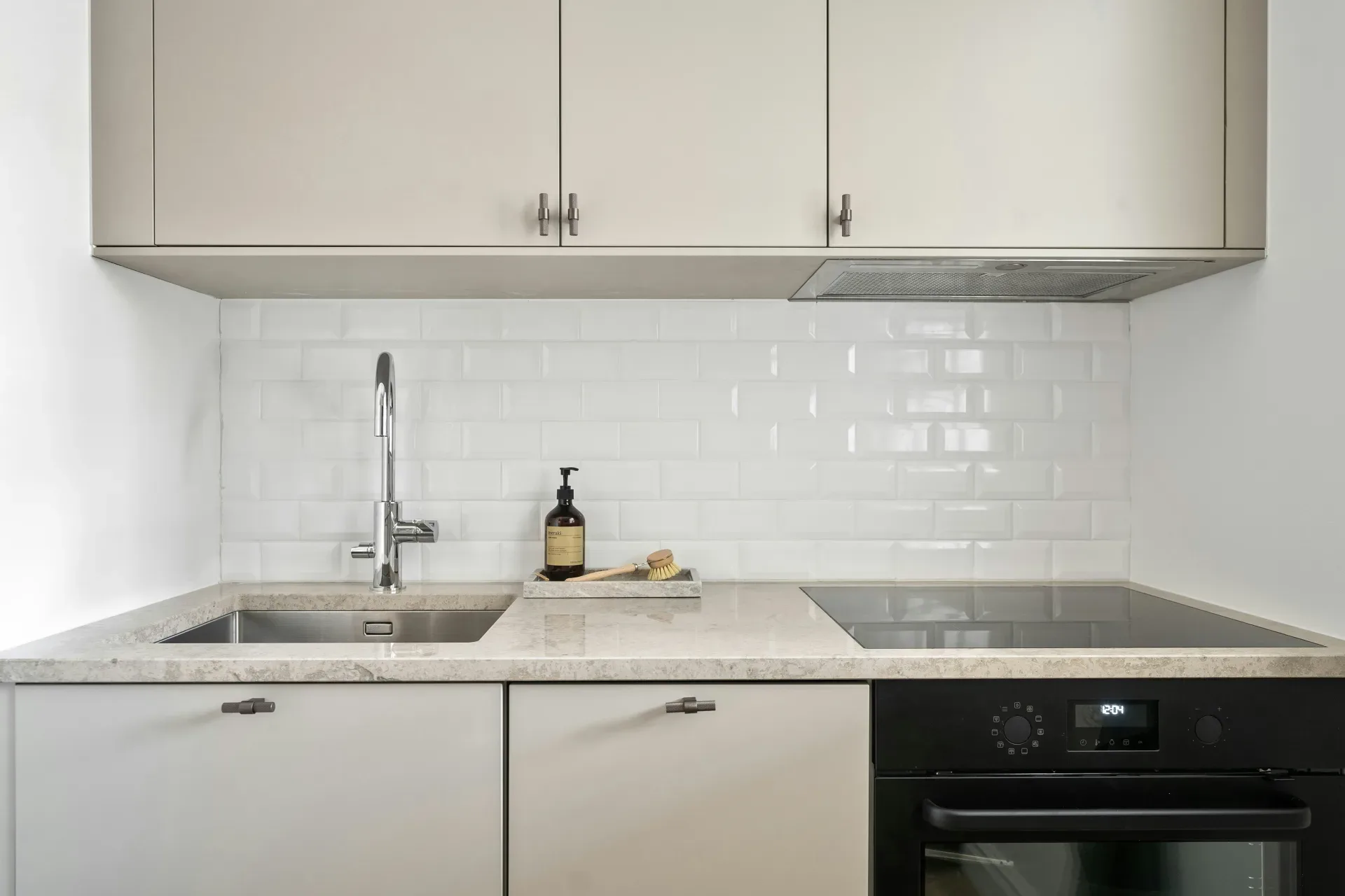 A kitchen with white cabinets and a black oven