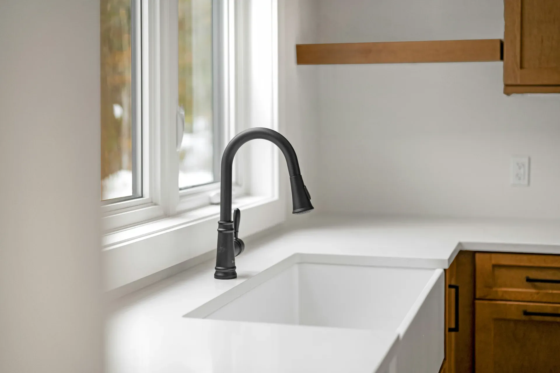A modern kitchen sink with a black faucet.