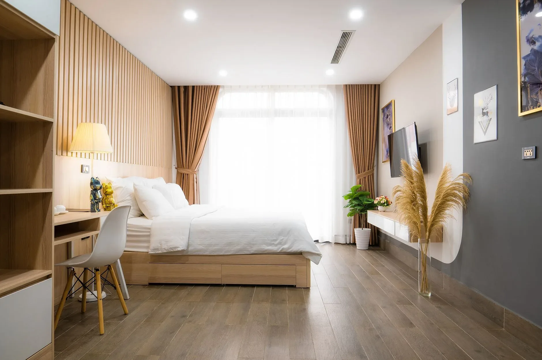 A modern minimalist bedroom with natural light, featuring cozy decor and wooden accents.