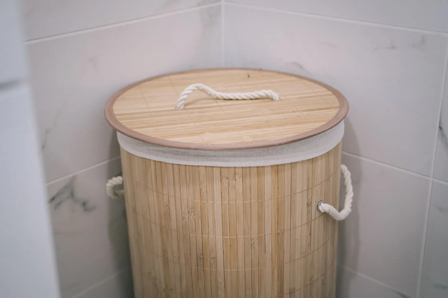 A stylish bamboo laundry basket adds a natural touch to a modern bathroom design.