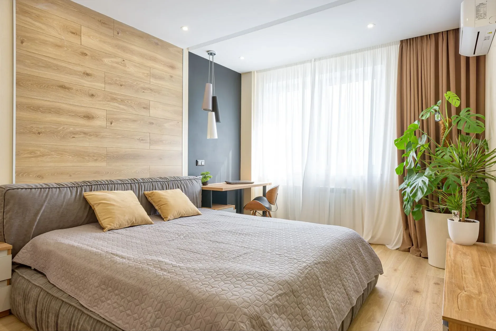 Bright modern bedroom with wooden accents, natural light, and cozy decor.