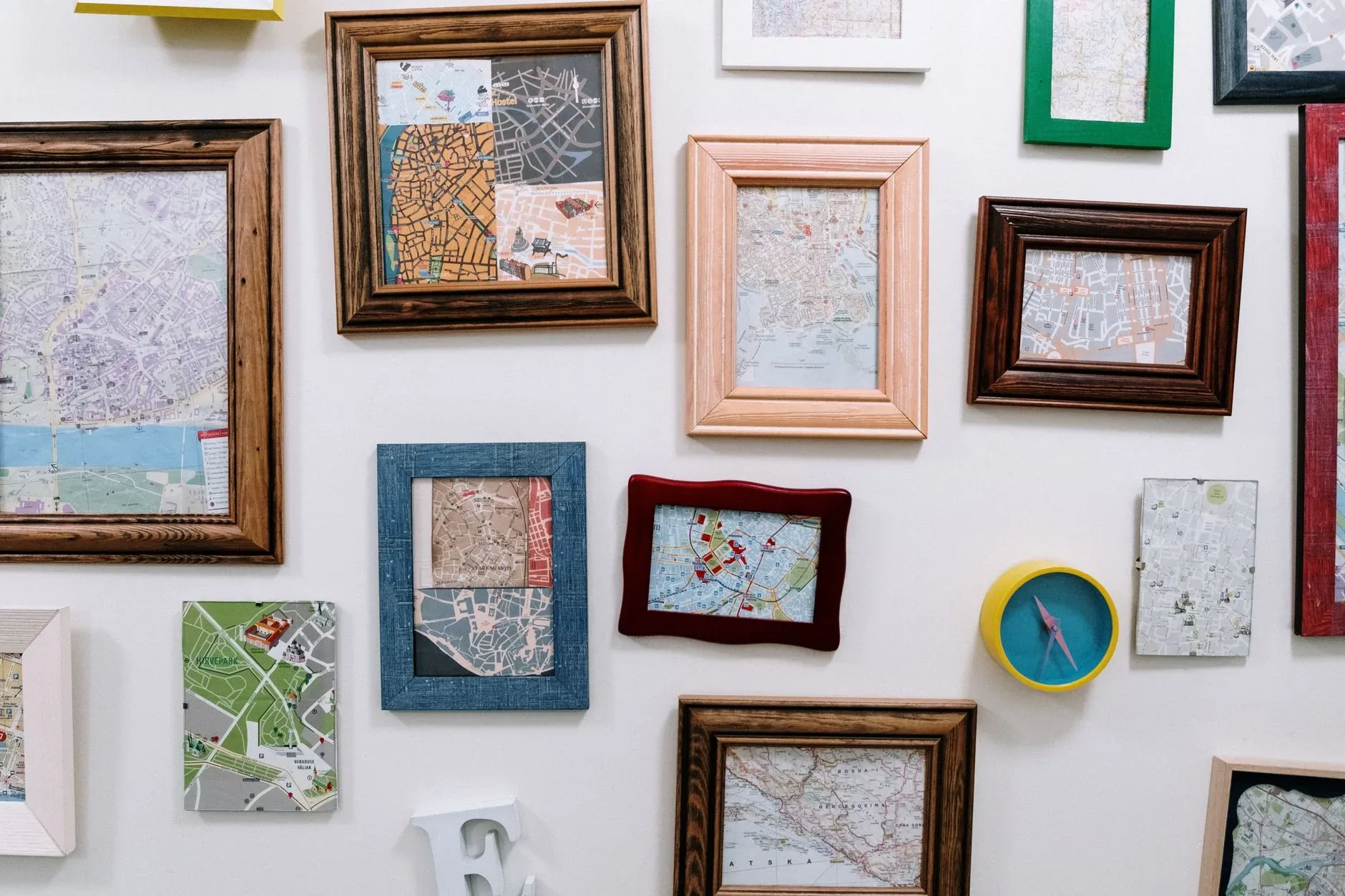 Creative wall arrangement featuring various maps in wooden frames, ideal for home decor.