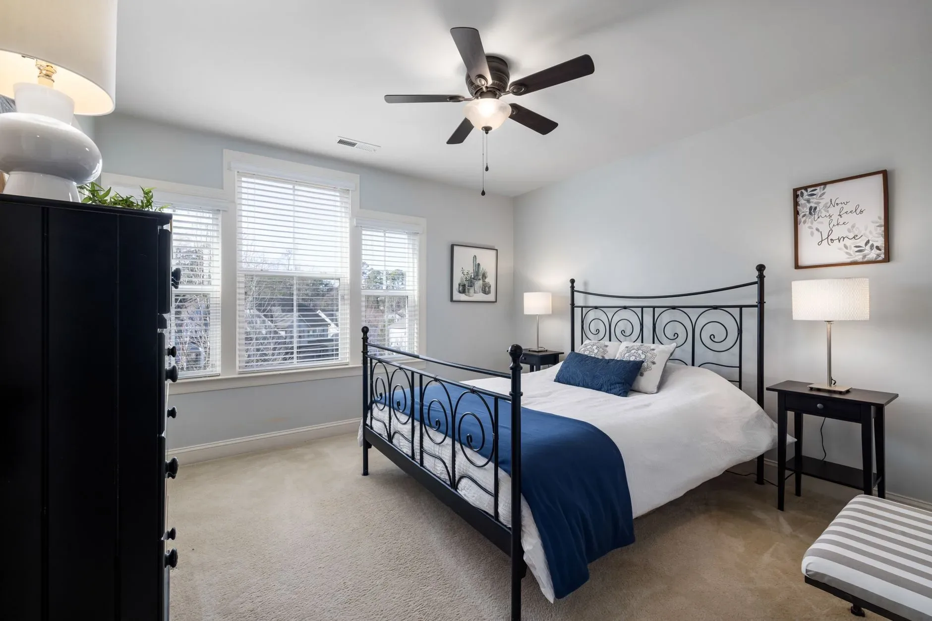 Modern bedroom featuring iron bedframe, elegant linens, and ambient lighting.