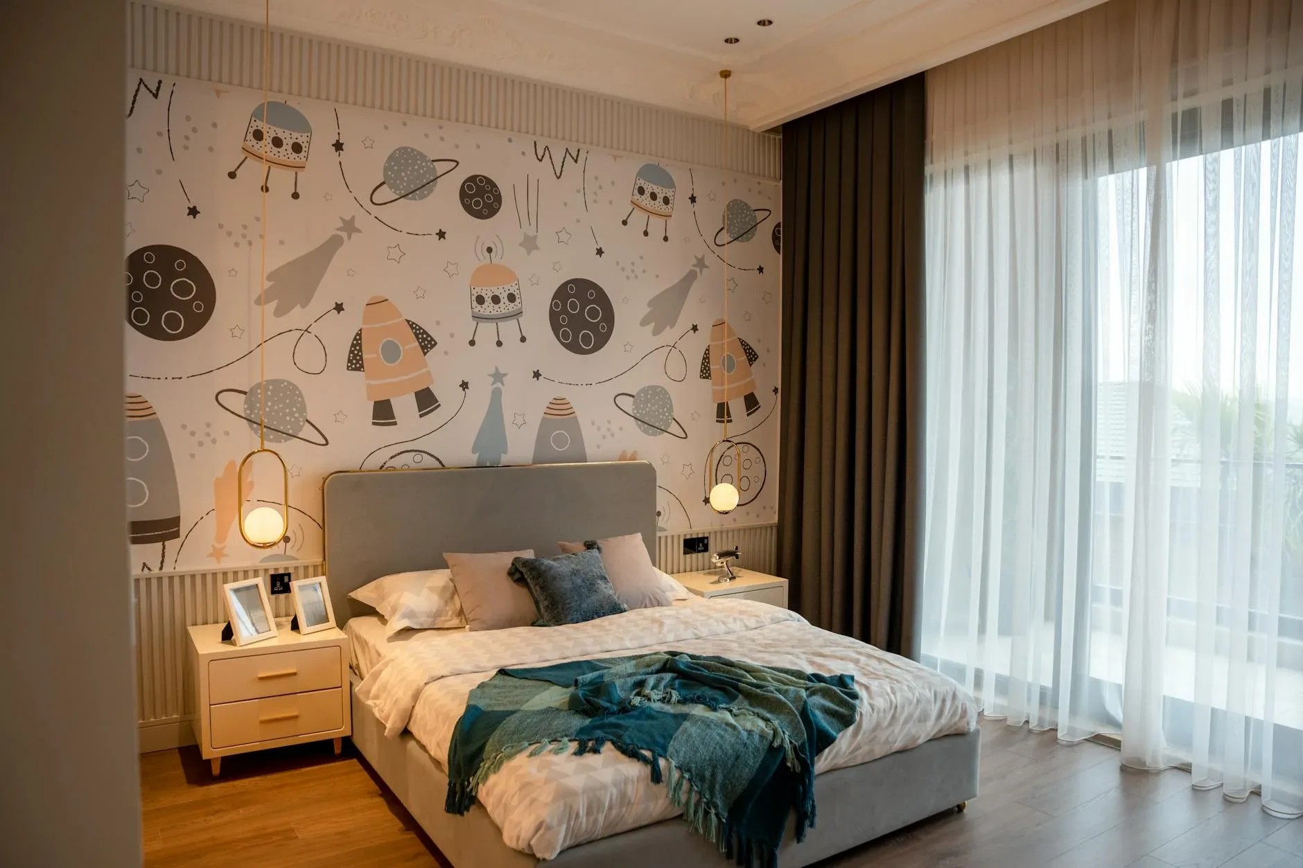 Modern bedroom featuring space-themed wallpaper, cozy bed, and soft lighting for a relaxed atmosphere.