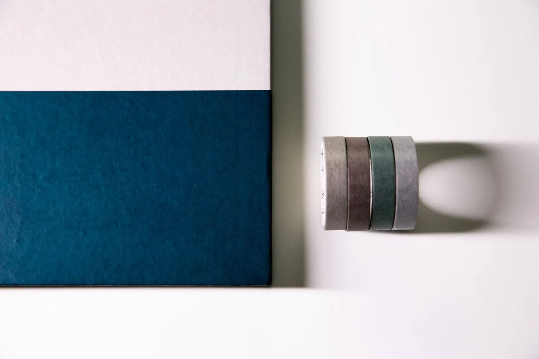 Overhead view of a notebook with washi tapes creating a minimalist design.
