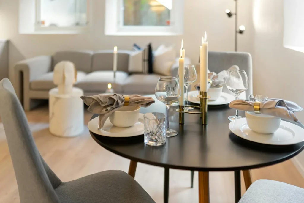 Sophisticated dining setup in a modern living room with candles and wine glasses.