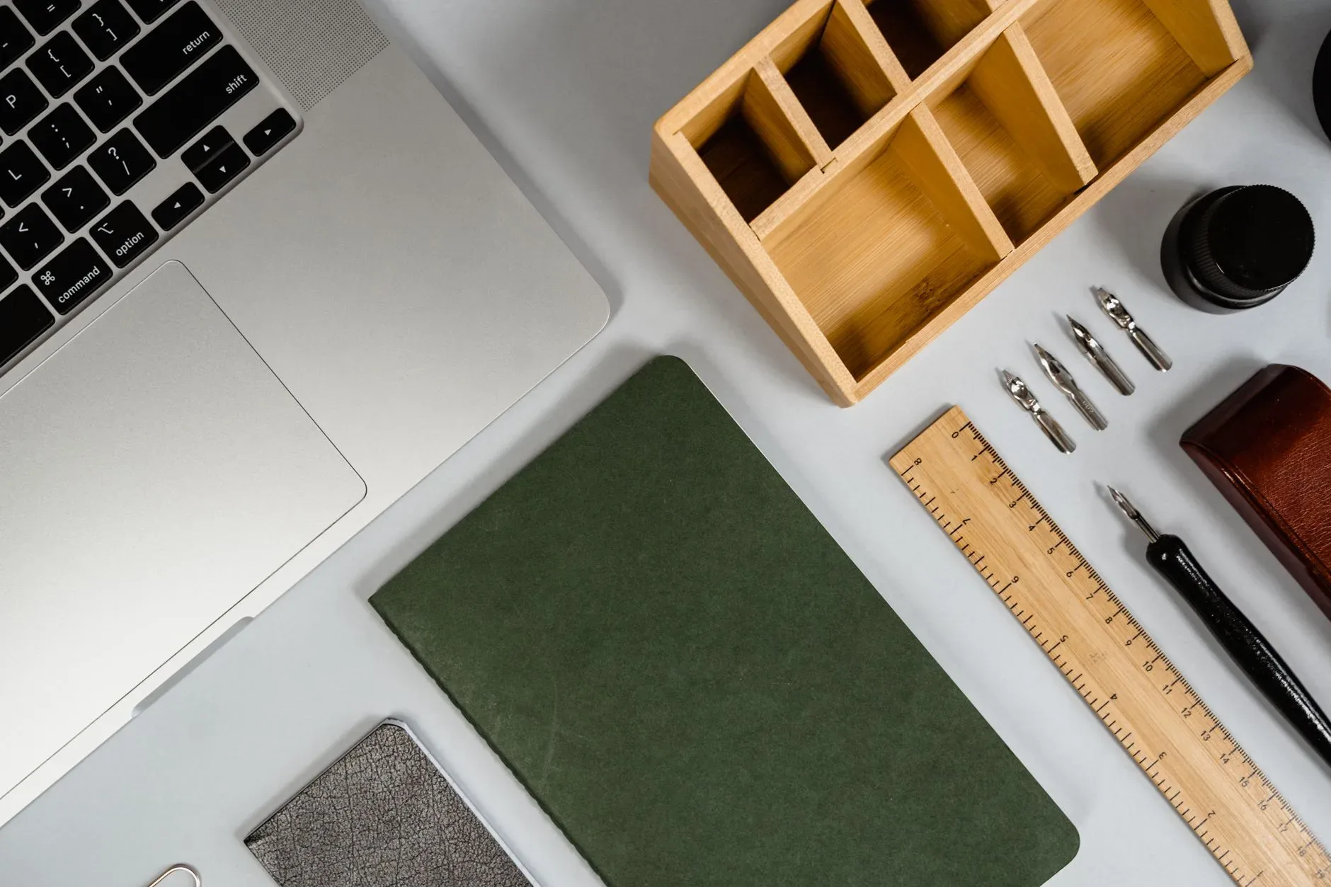 Stylish flat lay of creative workspace essentials including laptop, notebook, and pens.