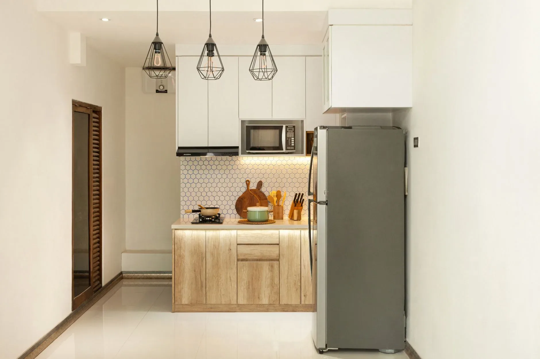 Stylish minimalist kitchen interior with wooden cabinets and sleek appliances.