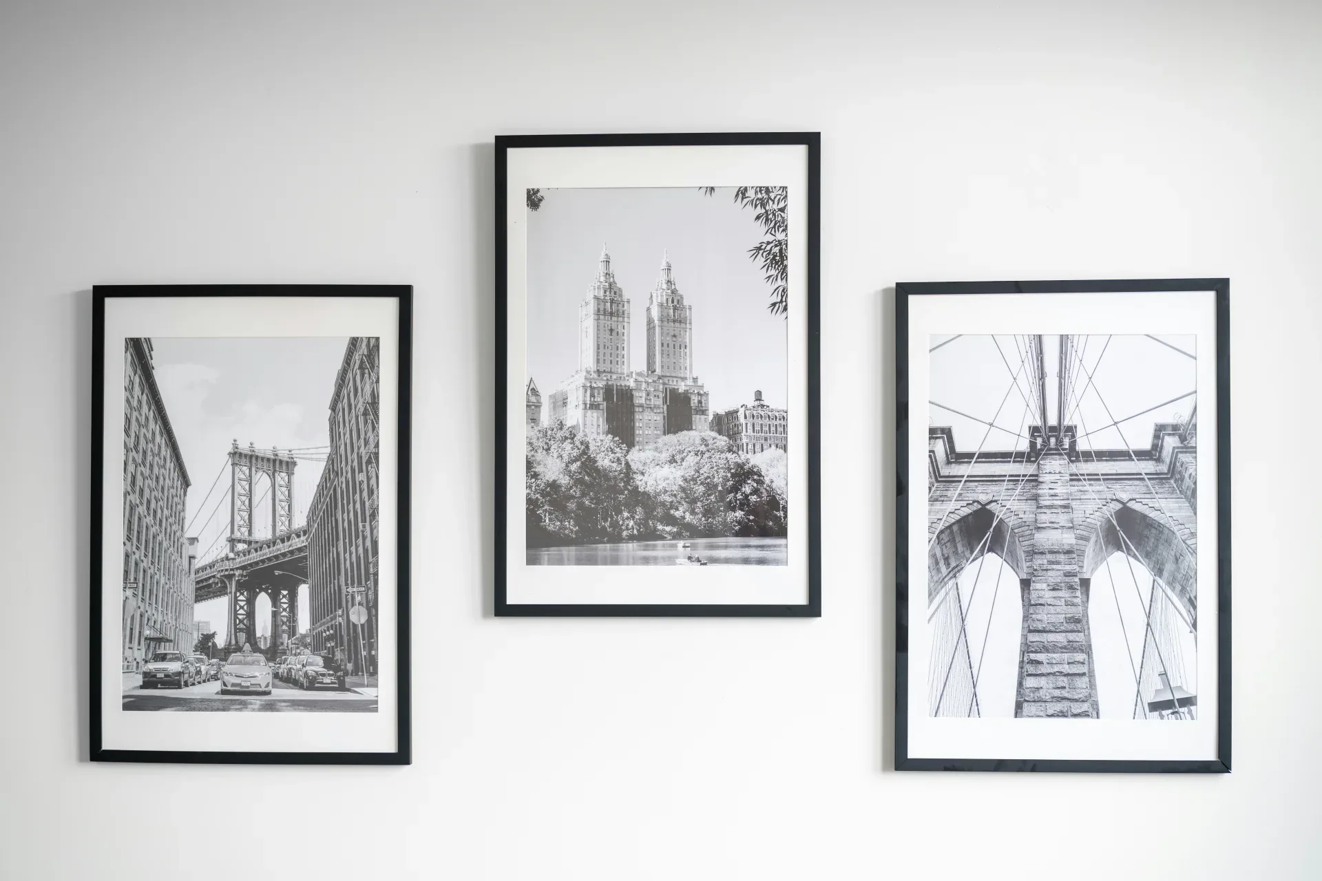 Three framed black and white cityscapes hang on wall