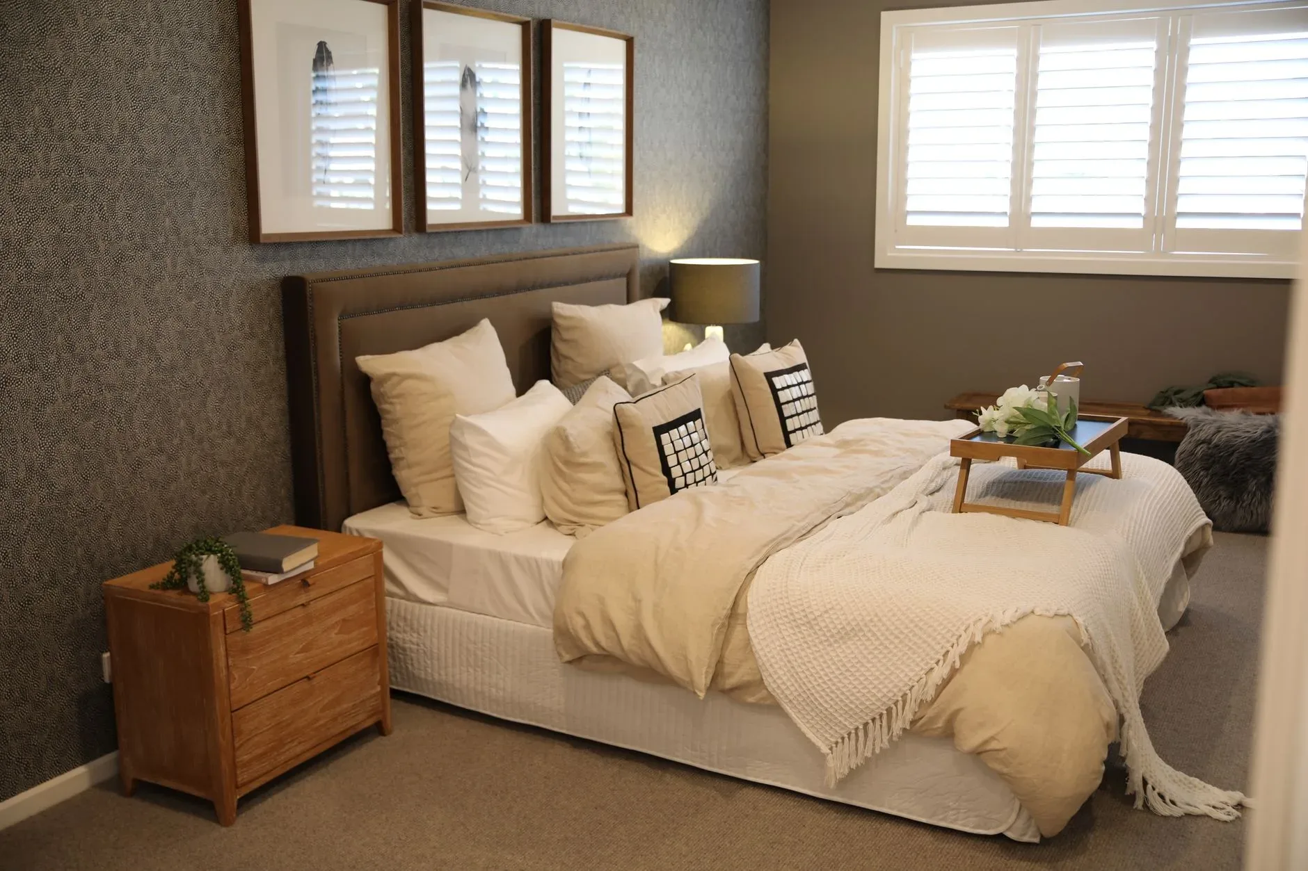 Warm and inviting modern bedroom with a neatly arranged bed and stylish decor.