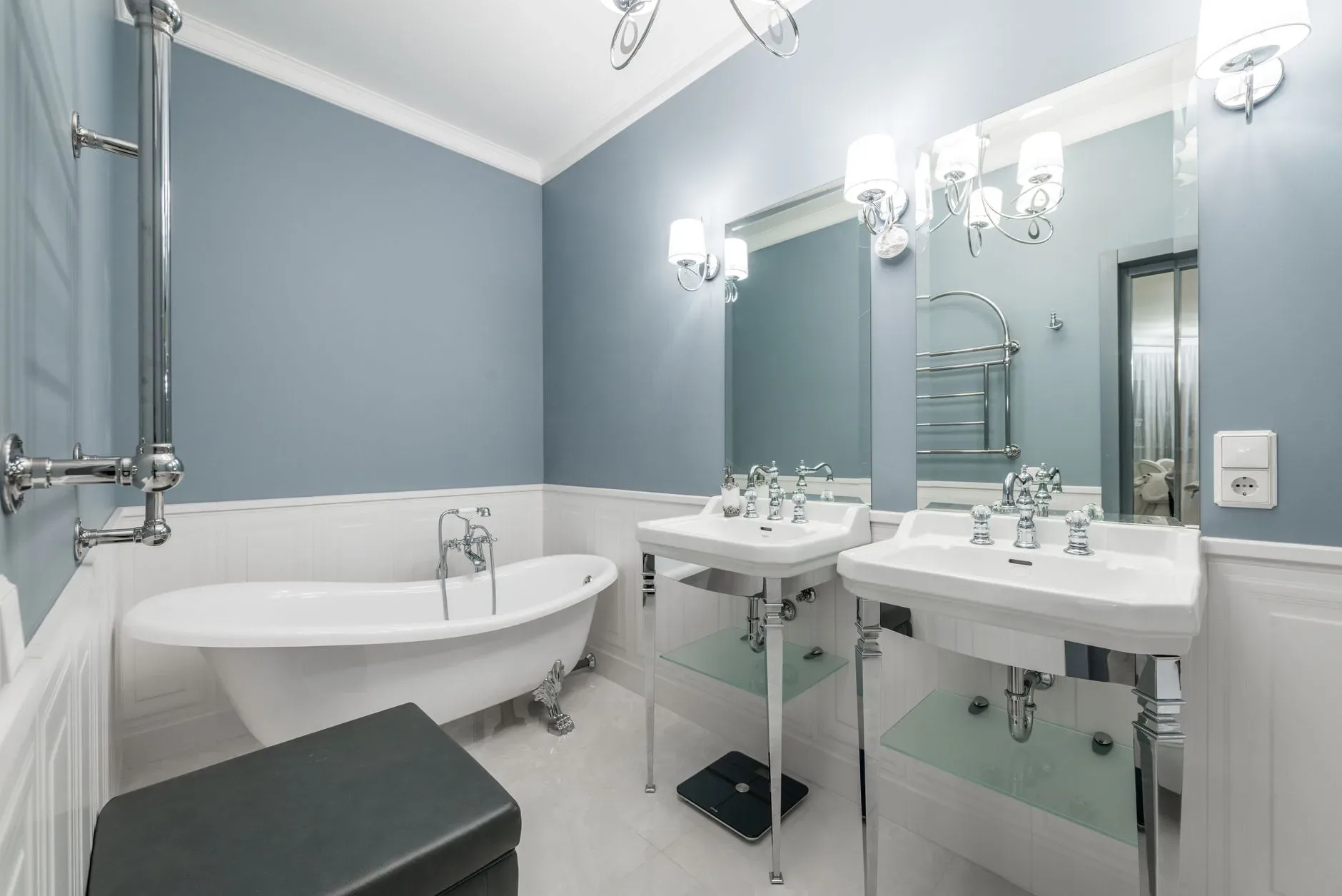 White bathtub placed near sinks under mirrors in light stylish bathroom in contemporary apartment