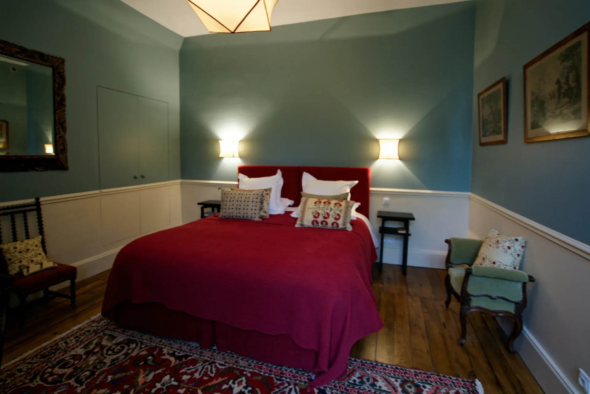 a bedroom with a red bed and a chair